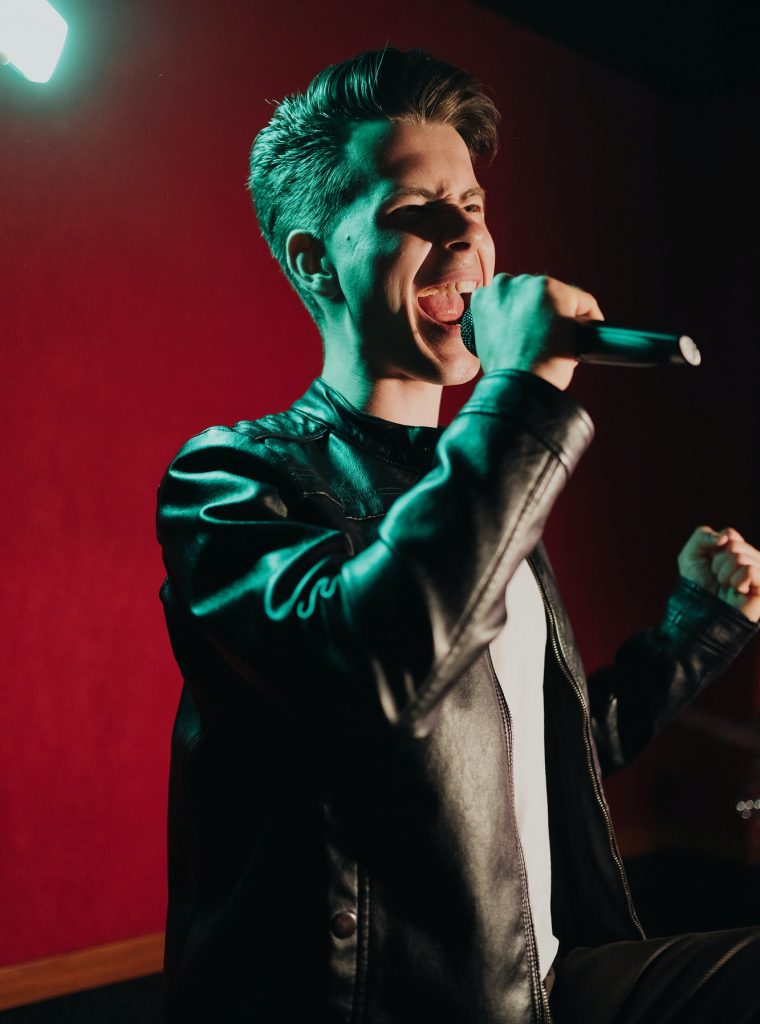 man-in-leather-jacket-performing-on-a-dark-stage-in-club.jpg